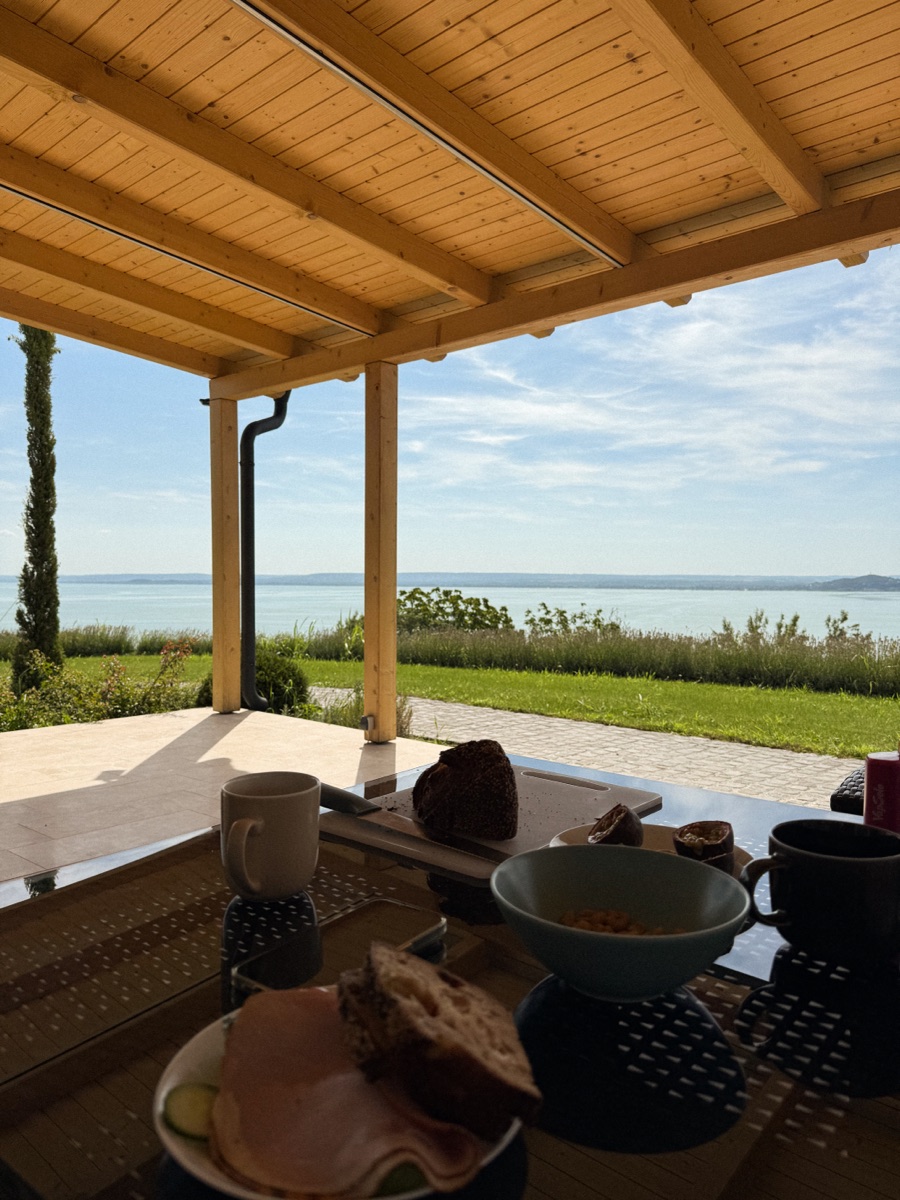 Kilátás a fedett teraszról a Balatonra, a pergola faoszlopai között